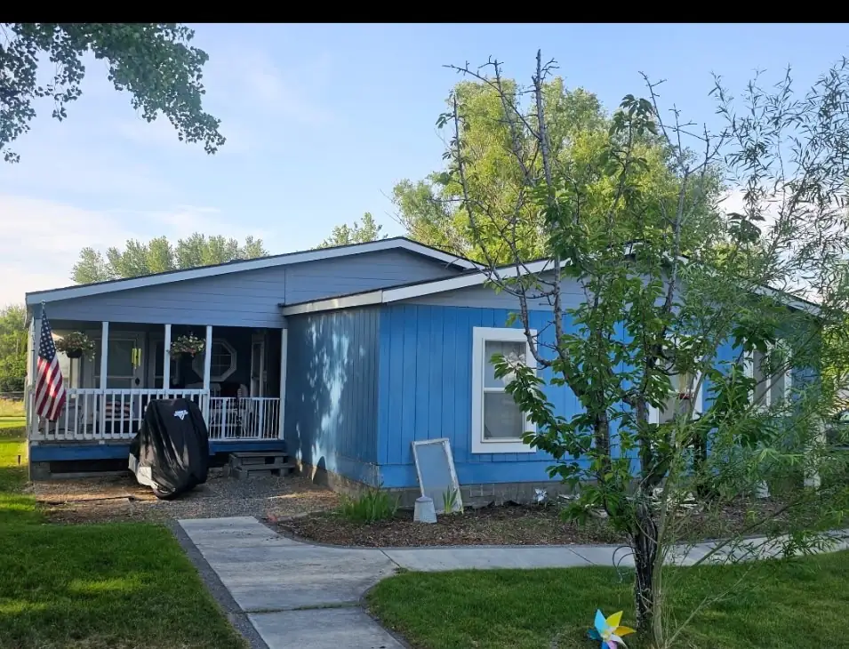 Before: covered porch with blue siding and American flag